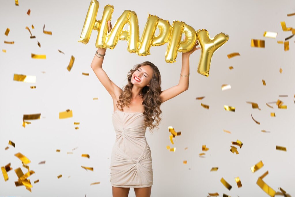 Woman in a dress holding up happy balloon for anniversary