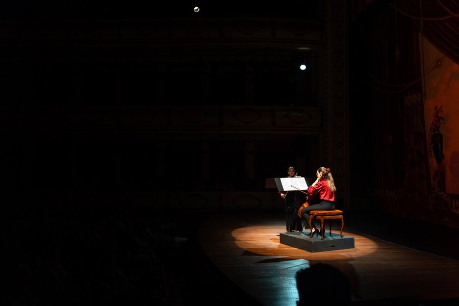 A woman performing a solo classical music concert in a theater