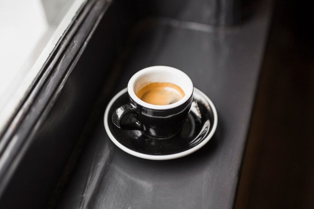 A cup of coffee left by a window