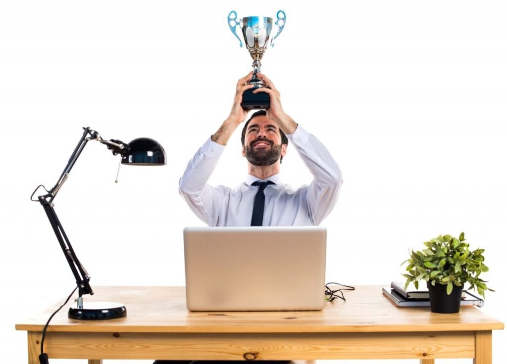 A man celebrating success with a trophy to inspire Instagram captions