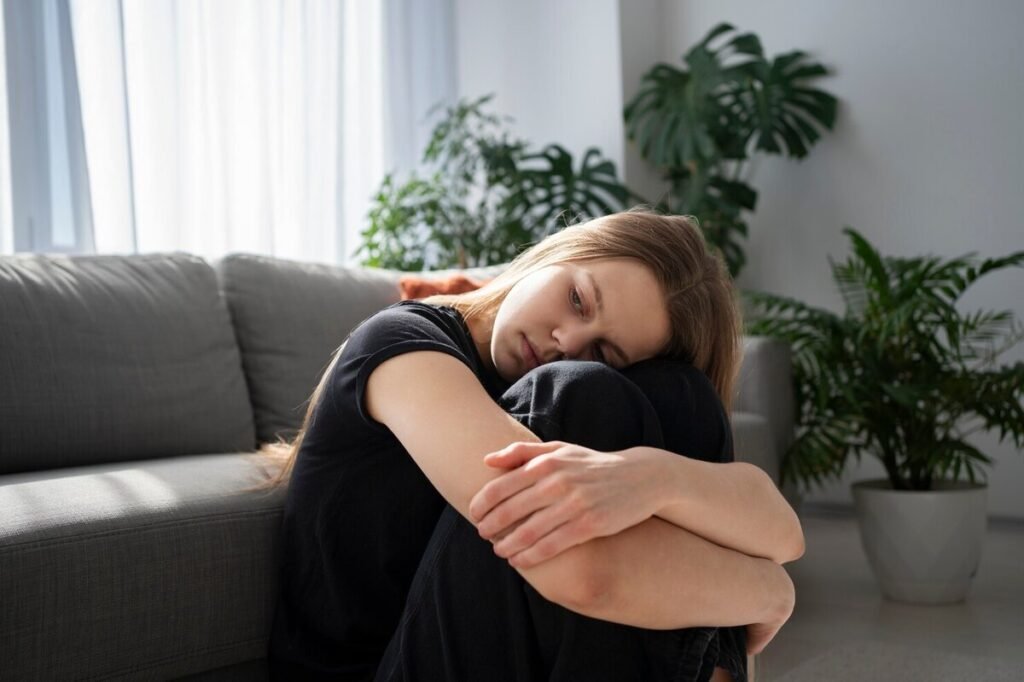 Young girl hugging her knees while upset