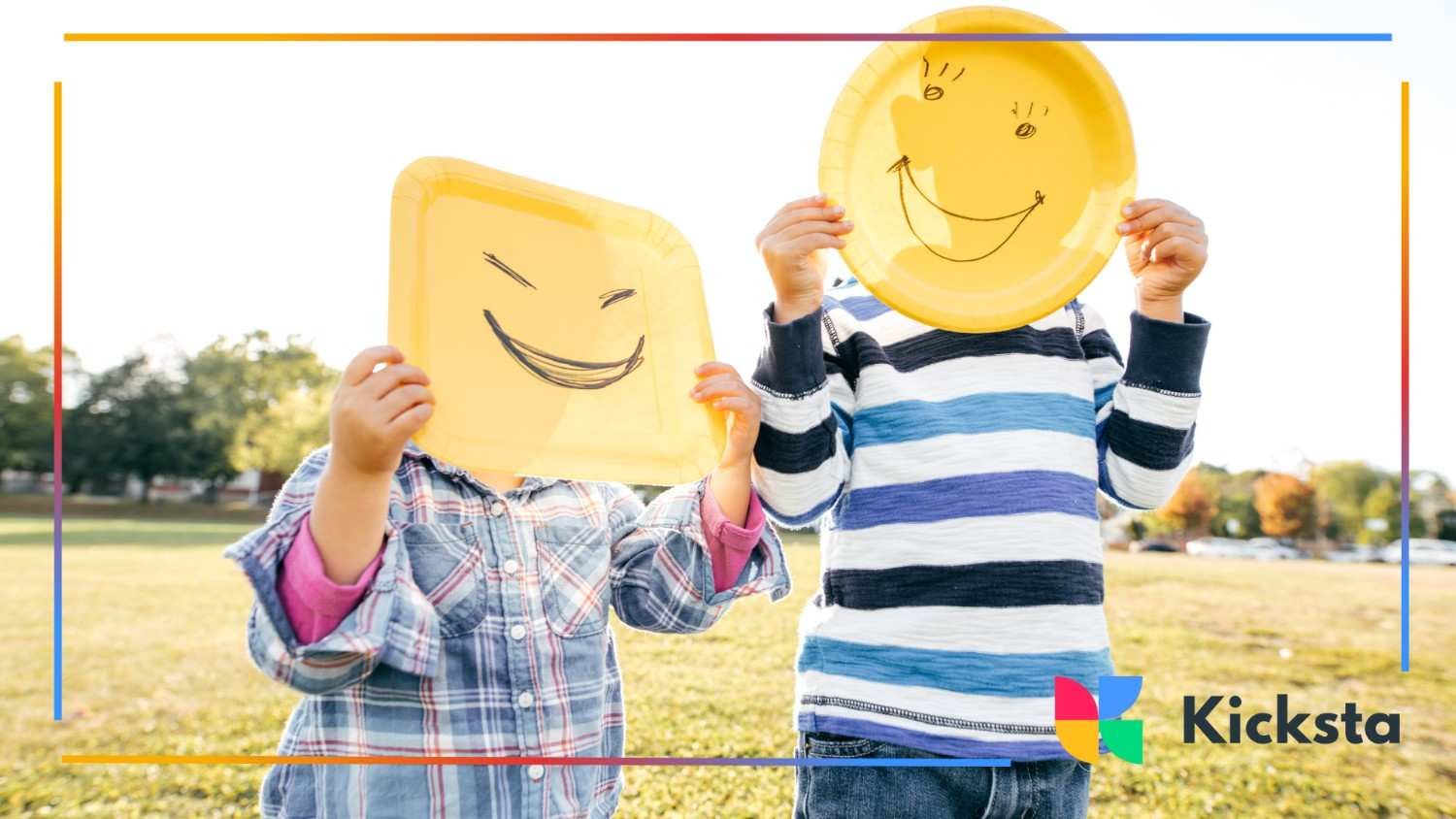 Two kids hold up yellow plates with drawn-on smiley faces, hiding their own