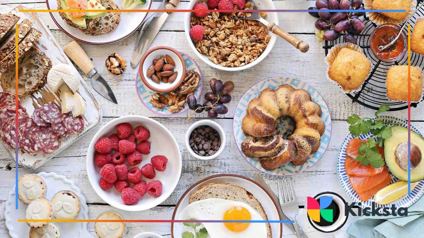 A vibrant brunch table filled with granola, berries, cold cuts, and pastries, perfect for a food influencer’s flat lay