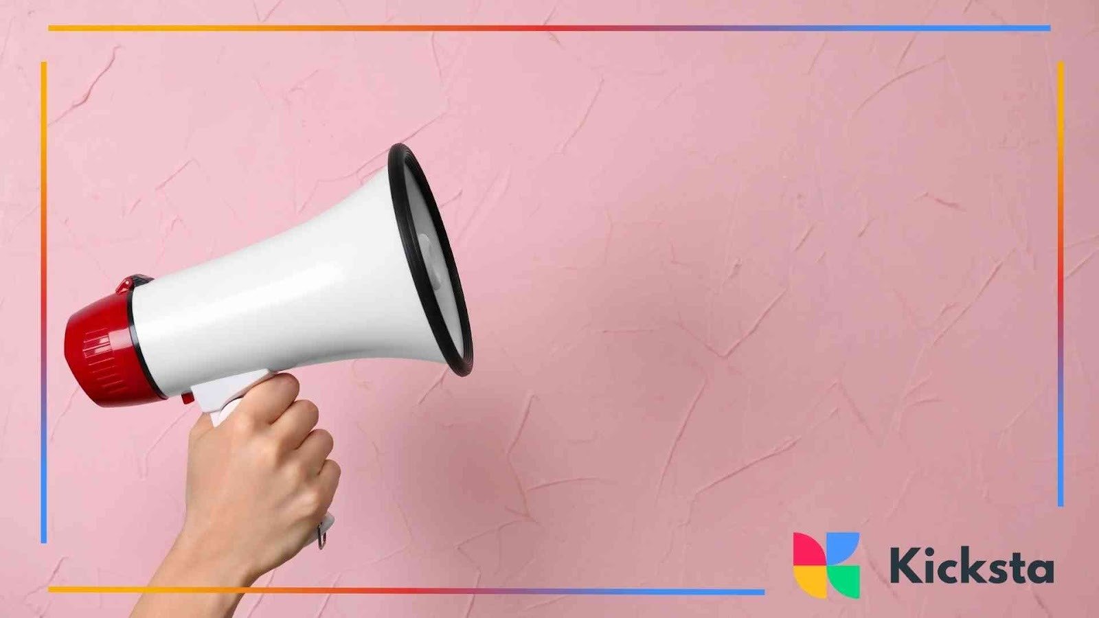 Hand holding a white and red megaphone against a textured pink wall background.