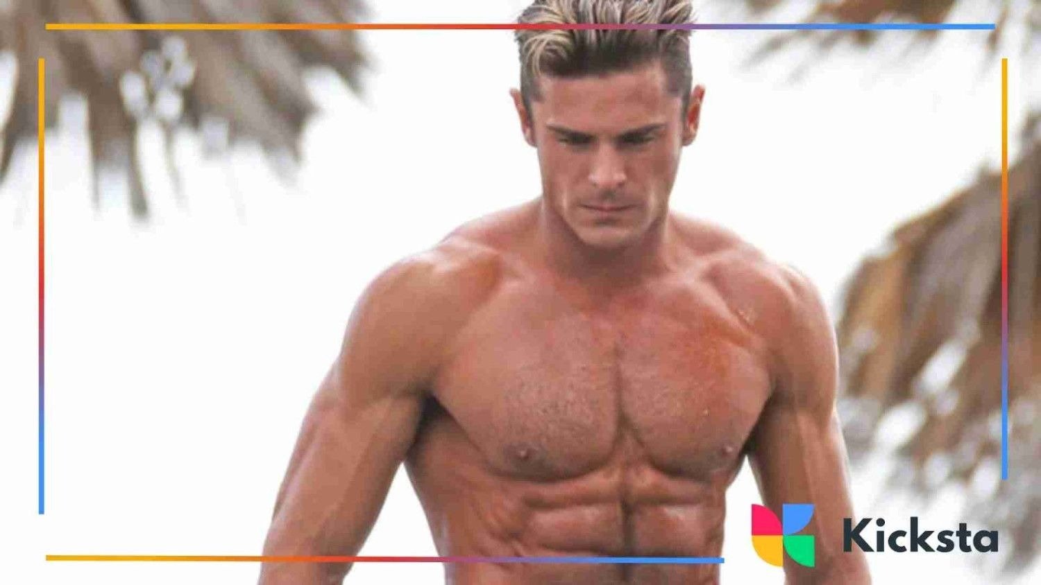 Zac posing shirtless outdoors, showing a muscular physique with blurred palm trees in the background.