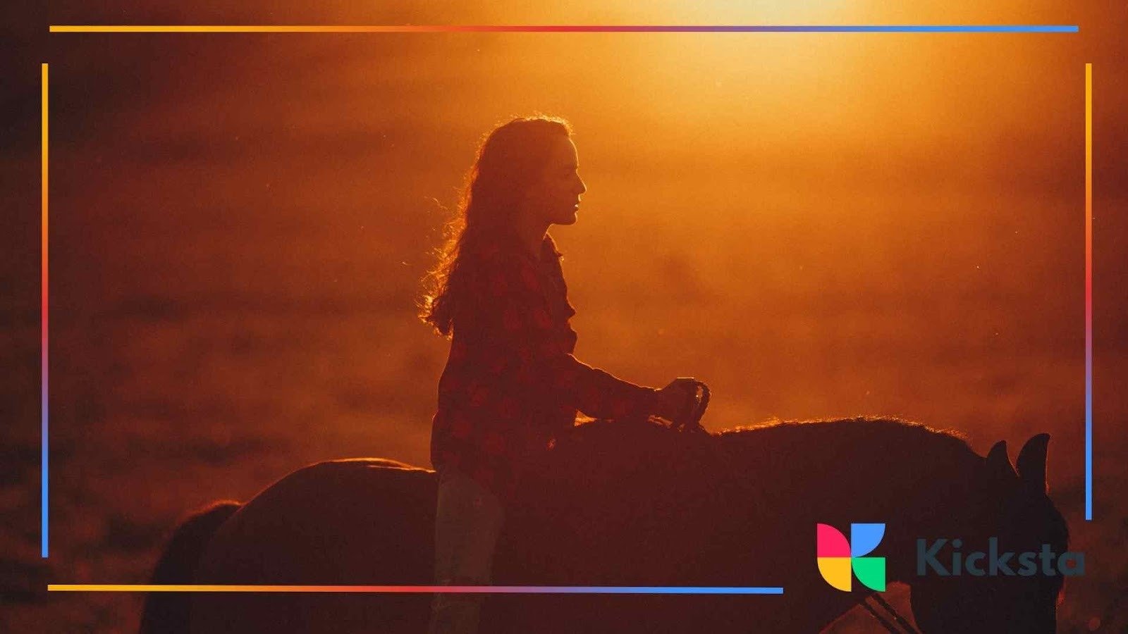 Silhouette of a person riding a horse at sunset with a deep orange glow filling the background.