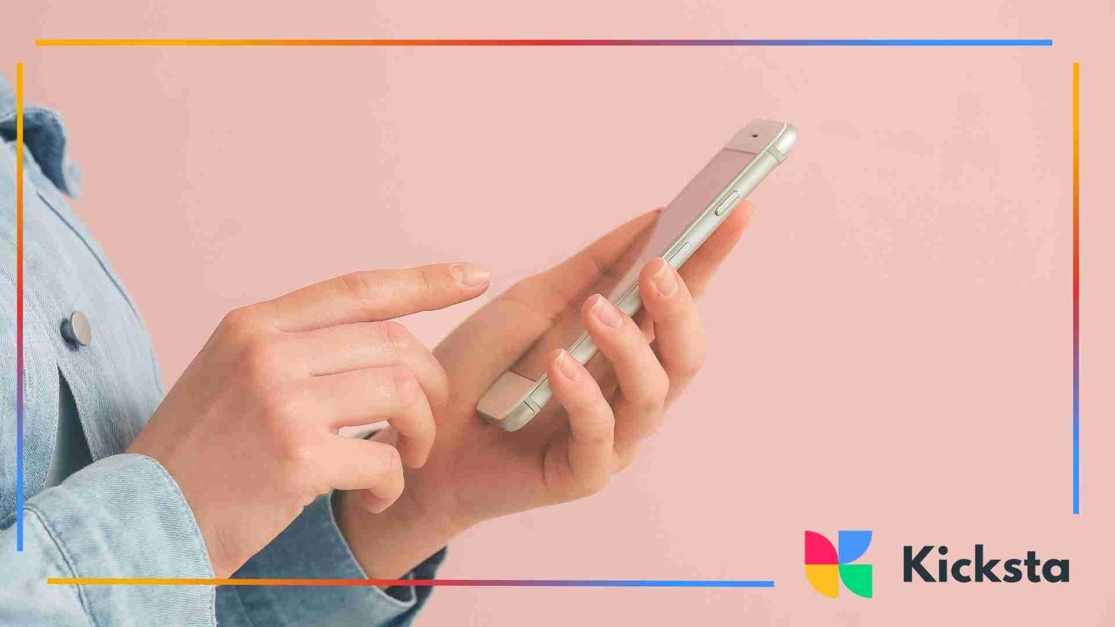 Close-up of a person holding and tapping a smartphone against a pastel pink background.