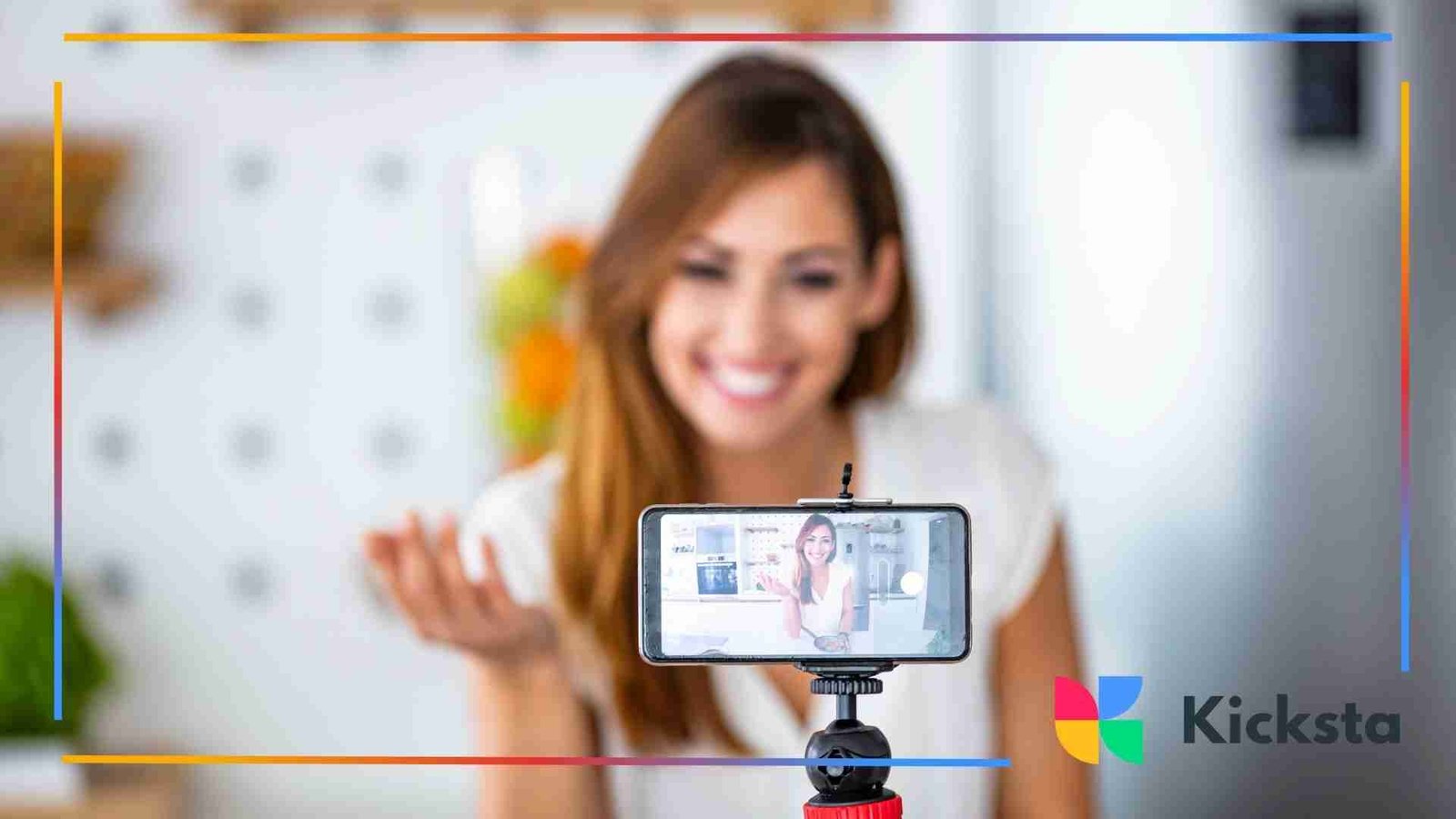 A smiling woman records herself on a smartphone mounted on a tripod, with the phone screen showing her speaking in a bright, indoor setting.