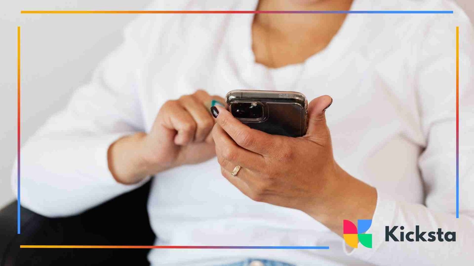 Close-up of a person in a white shirt using a smartphone, focusing on their hands and device.