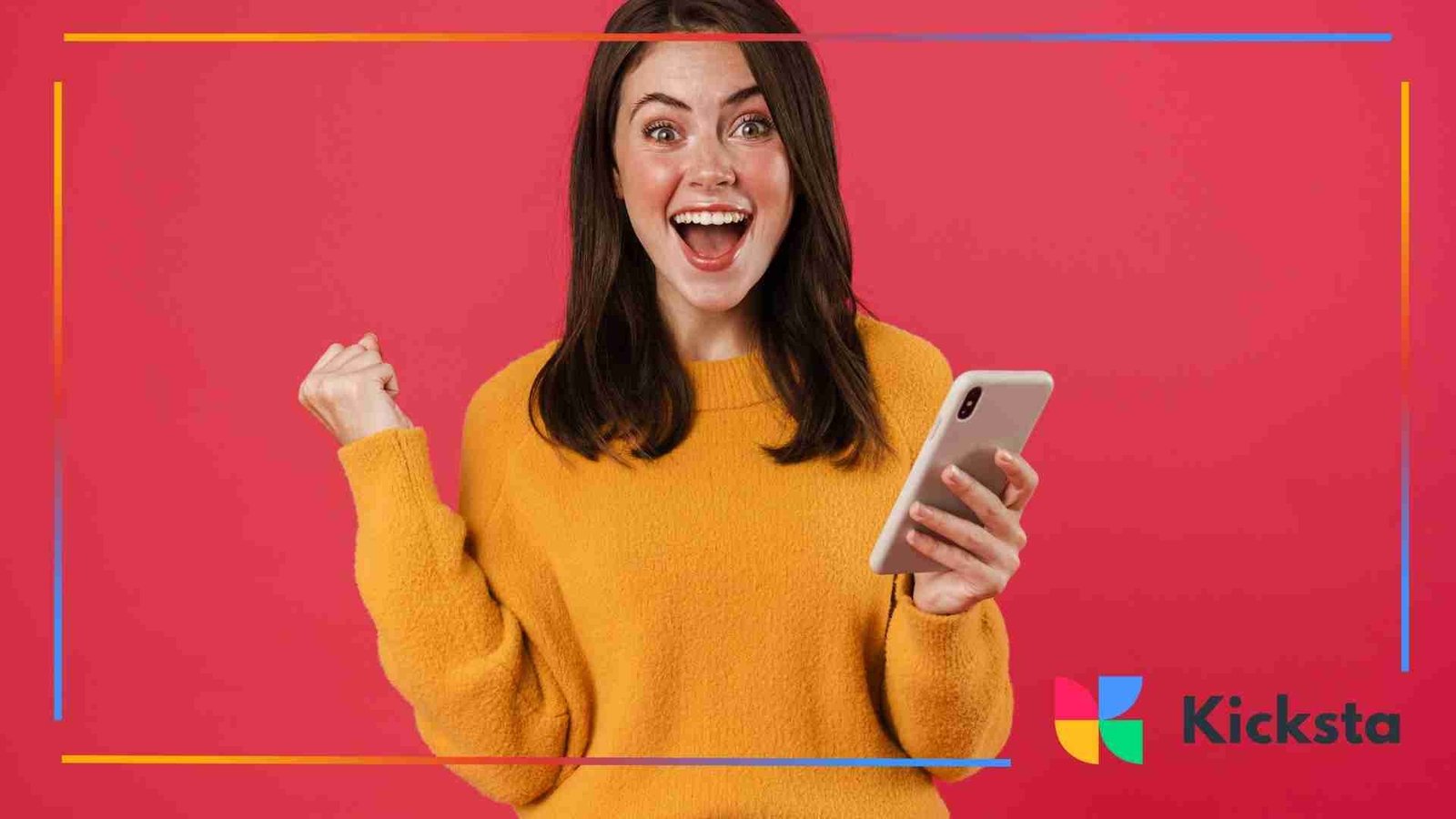 A cheerful woman in a yellow sweater celebrating while holding her phone in front of a bright pink background.