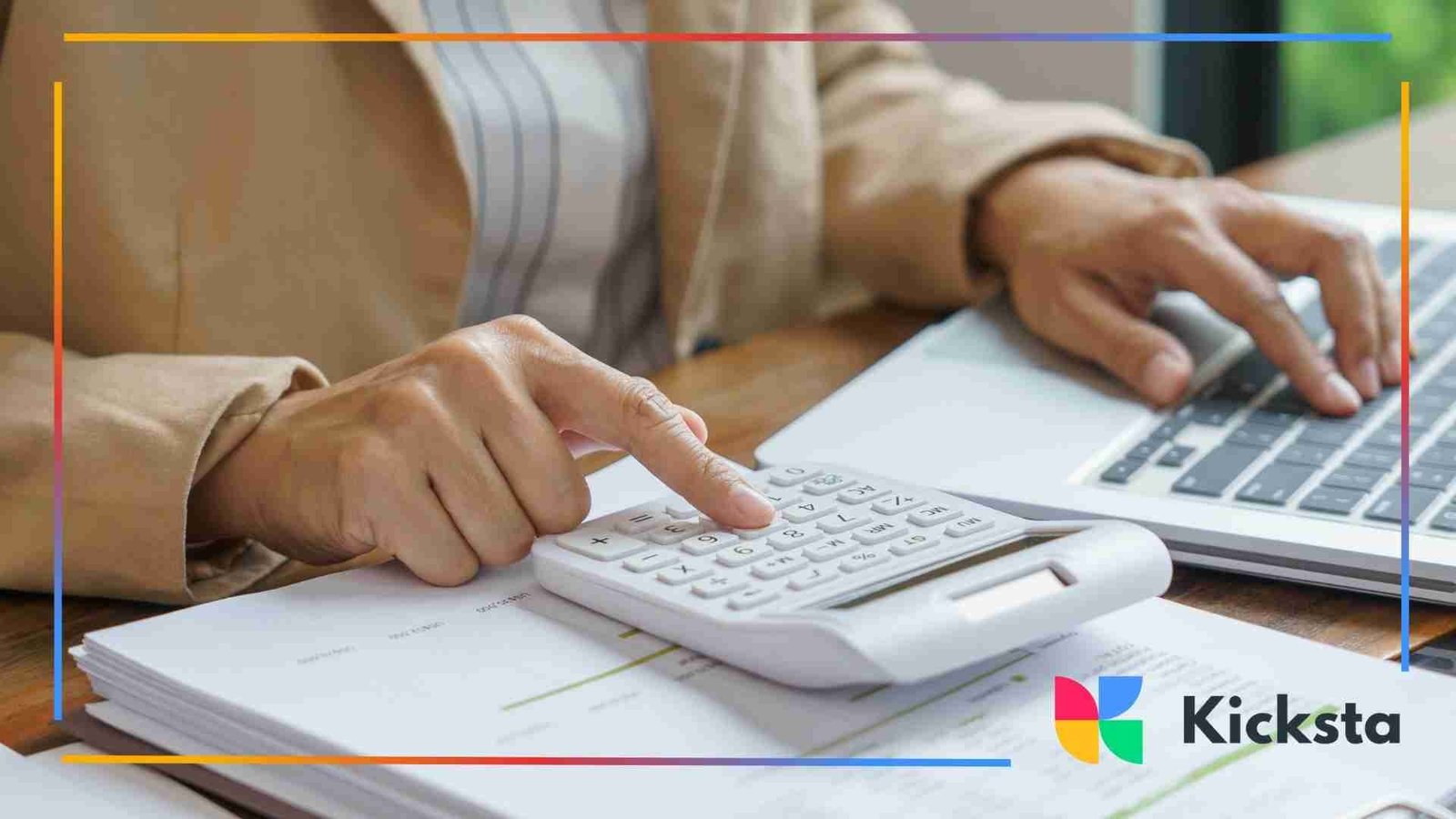 Person working at a desk with financial documents, using a calculator and laptop to review numbers.