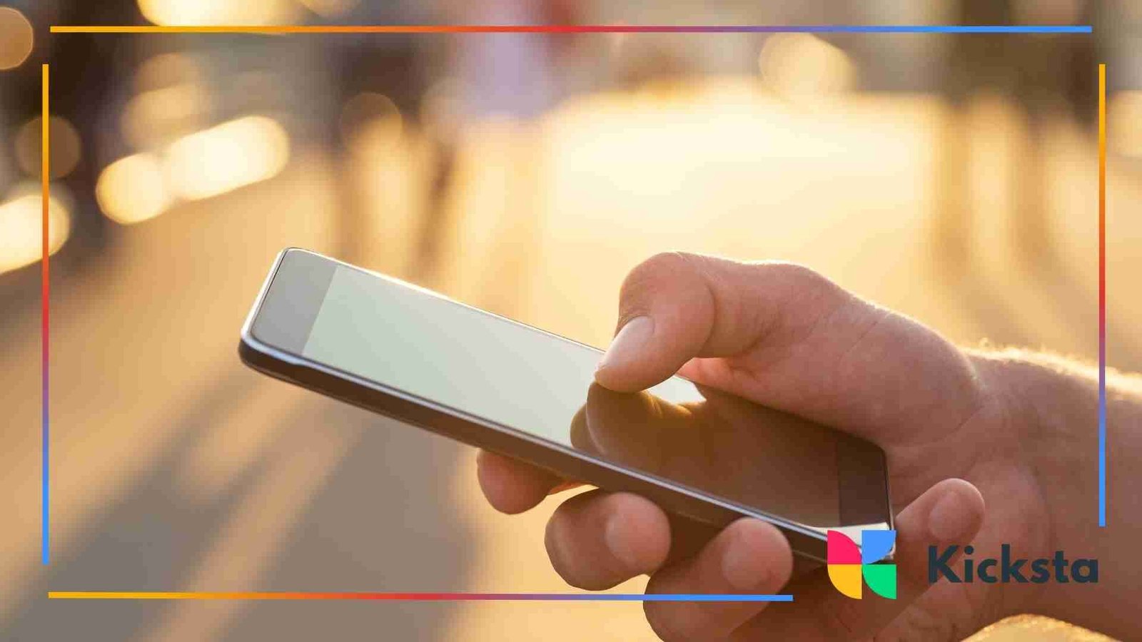 Close-up of a hand holding a smartphone outdoors with sunlight creating a warm, glowing background.