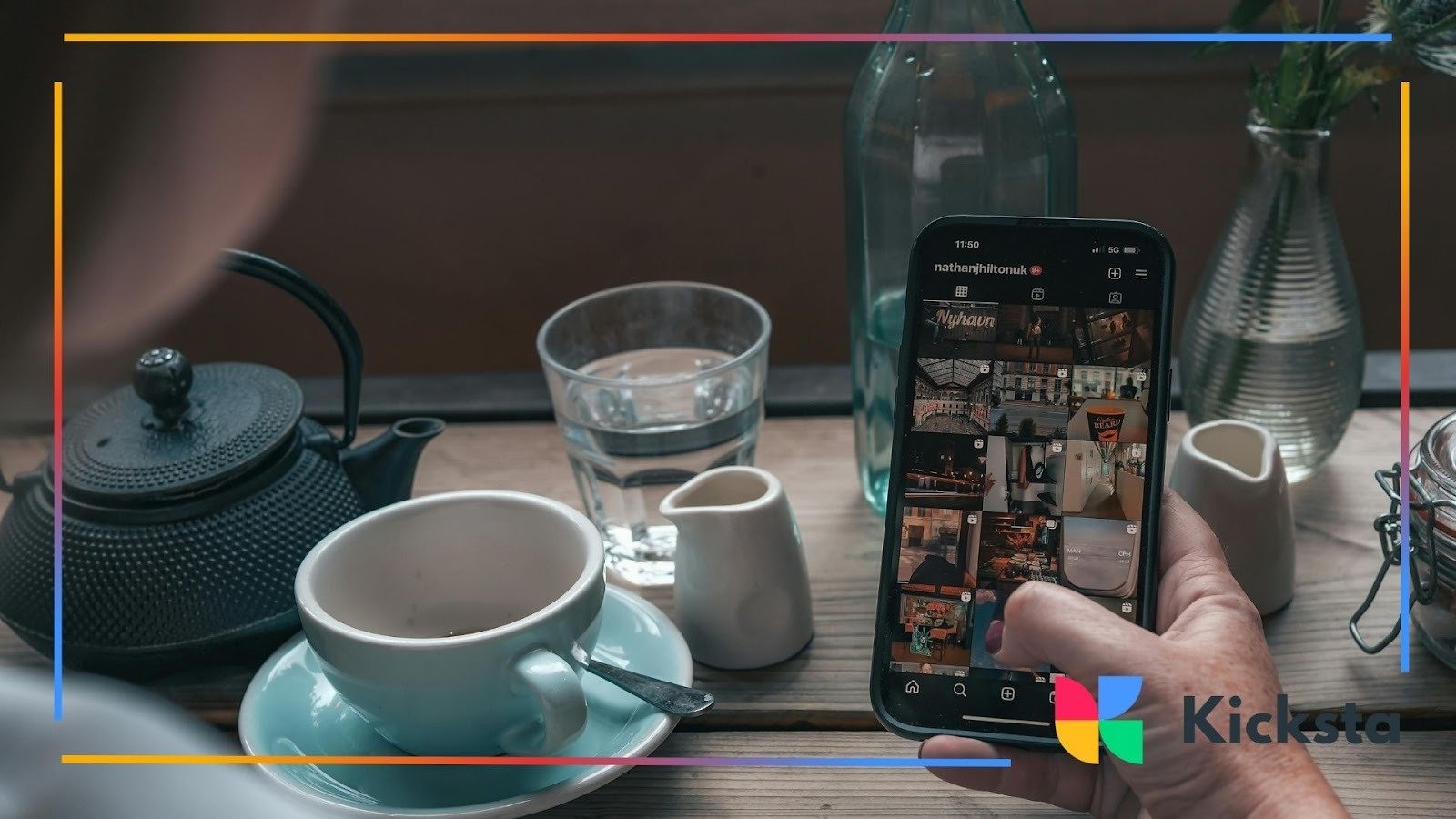 Person using smartphone to browse Instagram feed at café table with coffee and tea, representing social media engagement and digital lifestyle.