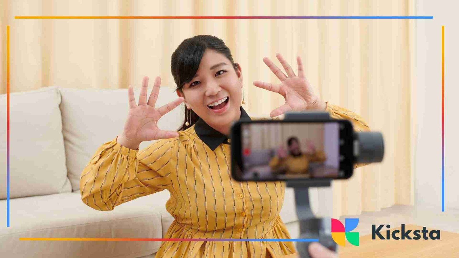 Smartphone on a tripod recording a woman indoors as she poses and smiles for a video.