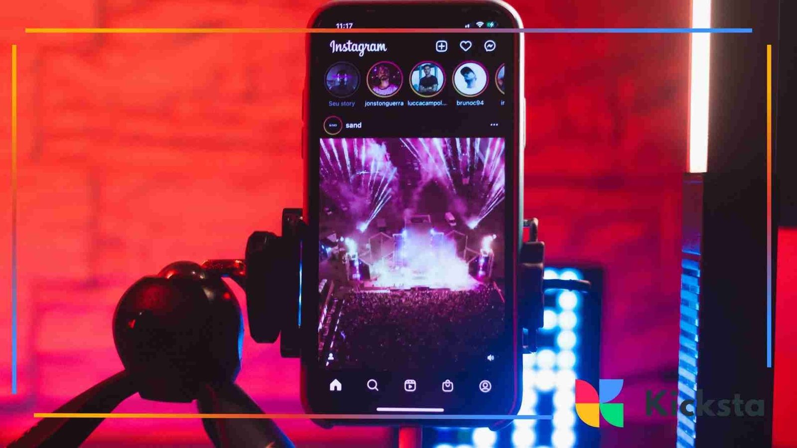Smartphone on a tripod displaying an Instagram feed with a concert scene on the screen.