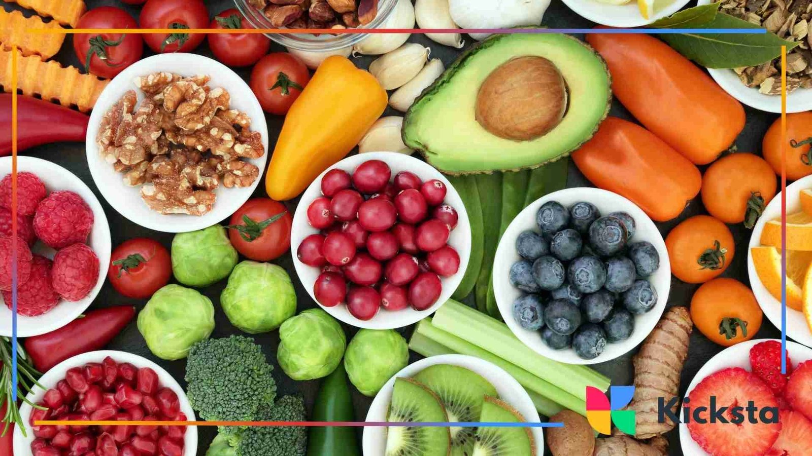 Flat lay of assorted fresh fruits, vegetables, nuts, and berries in bowls and scattered around, including kiwi, avocado, tomatoes, raspberries, and blueberries.