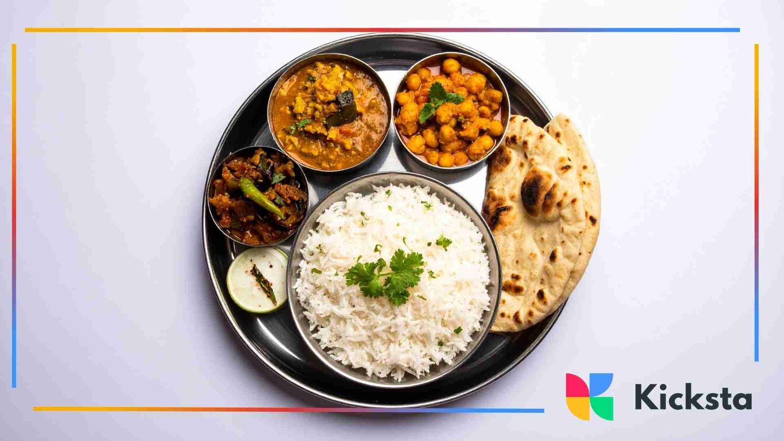 Traditional Indian thali plate with basmati rice, naan, chickpeas, vegetable curry, and assorted sides arranged neatly on a white background.