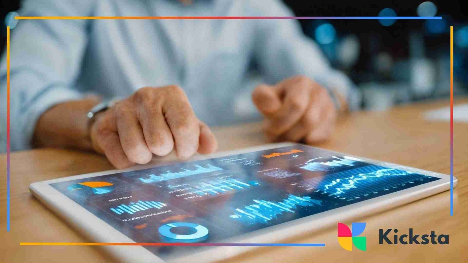 Hands using a tablet displaying analytics charts and data visualizations on a desk