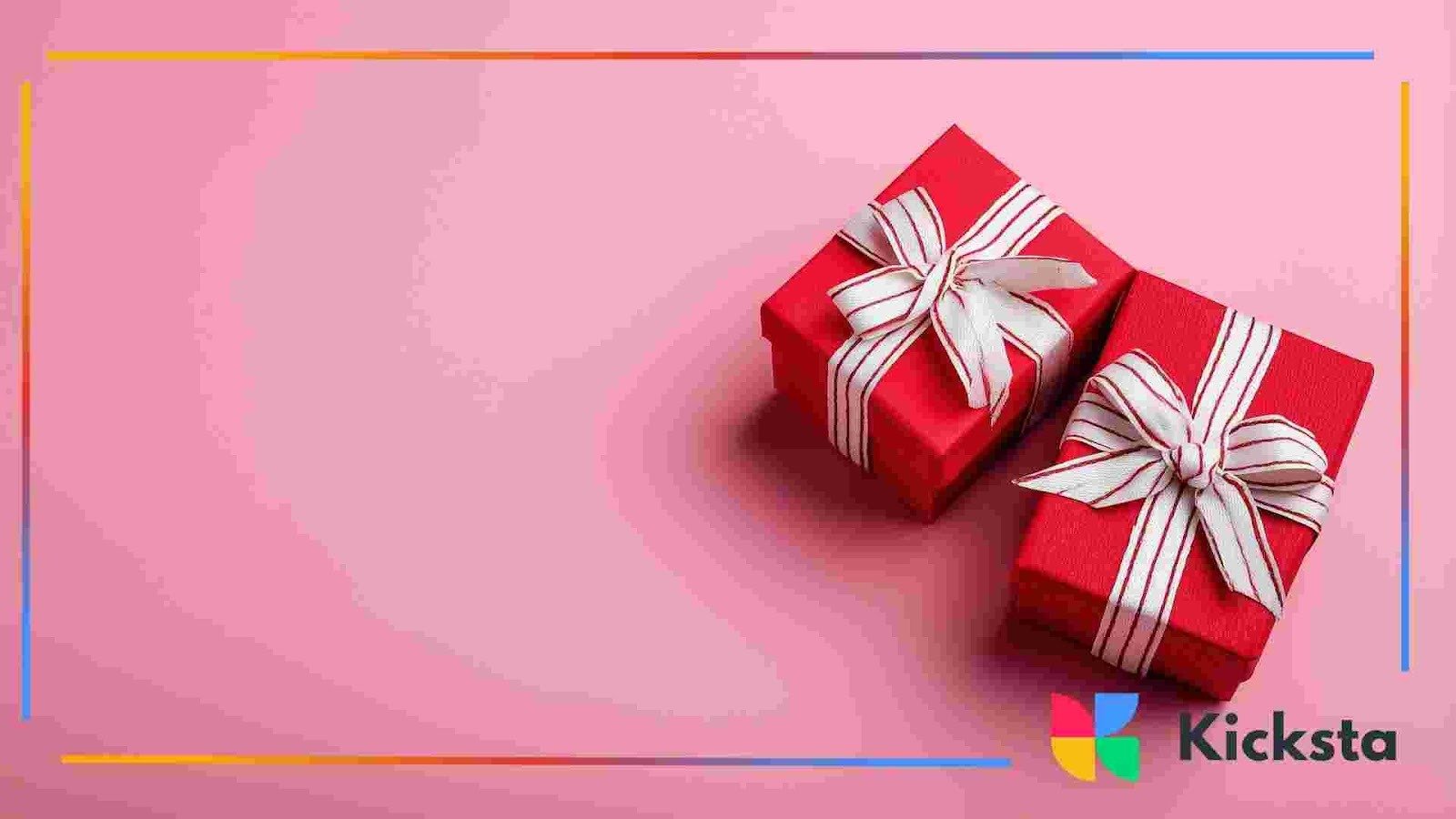 Two red gift boxes wrapped with white ribbon placed on a pink surface.