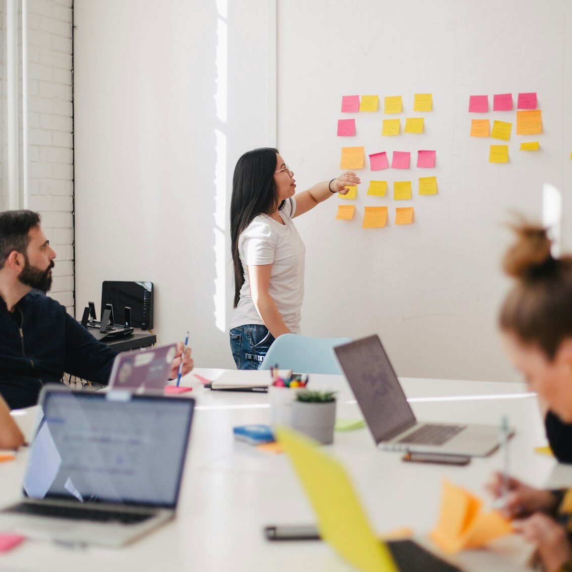 Marketing team planning a growth strategy on a wall of sticky notes